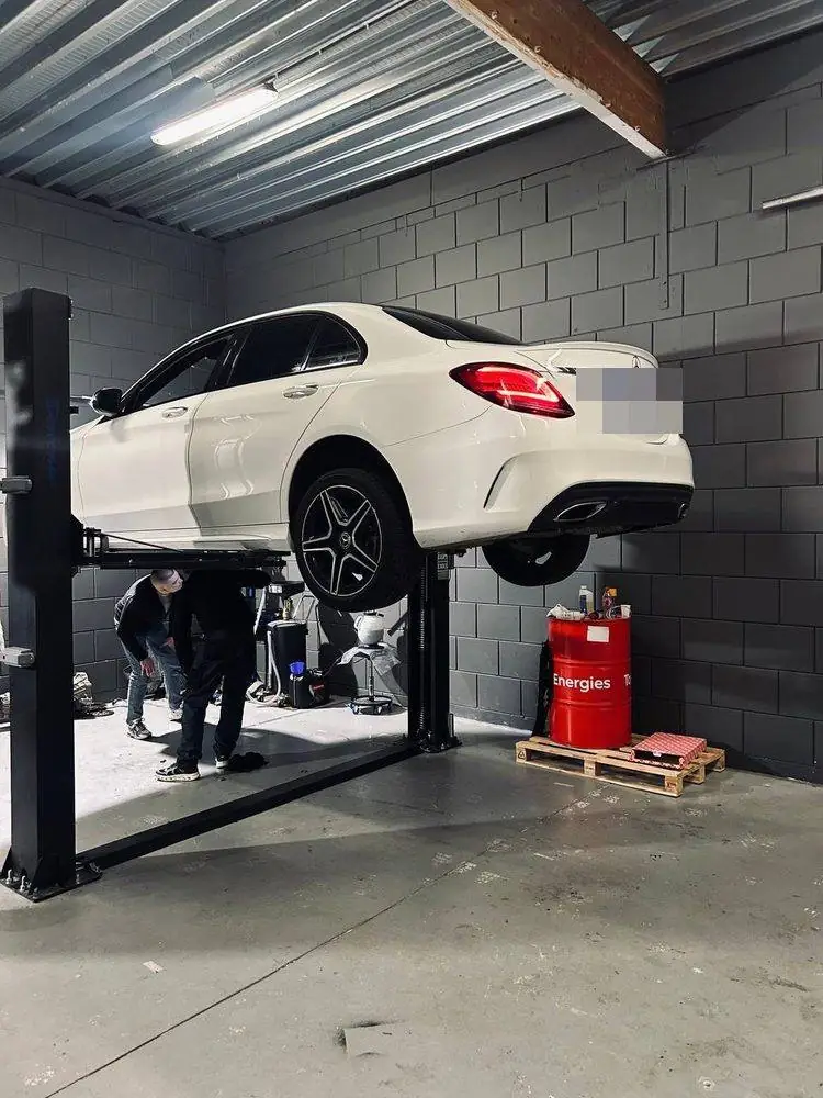 Monteur van AutoJet voert onderhoud uit aan een Mercedes op de hefbrug in de werkplaats in Almere